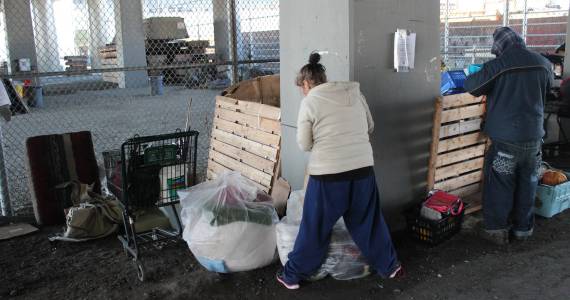 A pair of homeless campers pack up before being evicted from under the Ballard Bridge. Photo by Casey Jaywork.