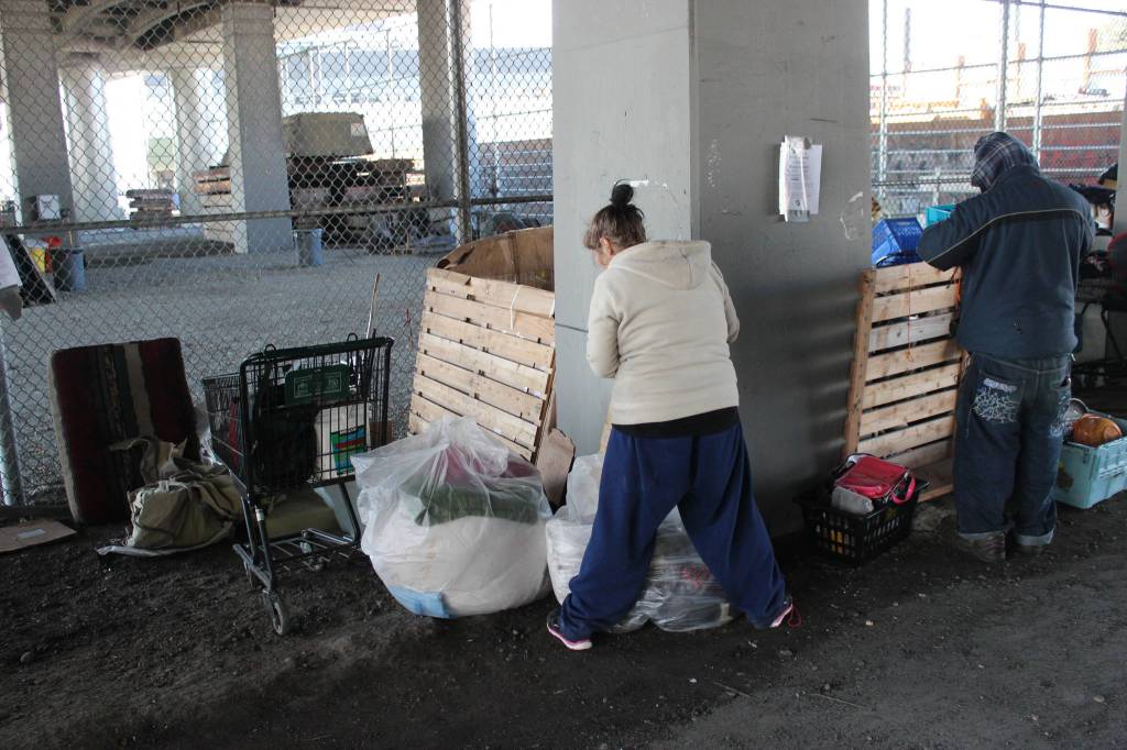 A pair of homeless campers pack up before being evicted from under the Ballard Bridge. Photo by Casey Jaywork.
