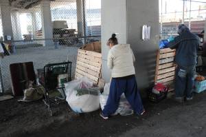 A pair of homeless campers pack up before being evicted from under the Ballard Bridge. Photo by Casey Jaywork.