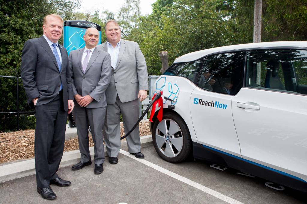 Mayor Ed Murray, Woodland Park Zoo CEO Alejandro Grajal, and ReachNow CEO Steve Banfield mug for the camera in front of the new EV charging station. Photo courtesy ReachNow