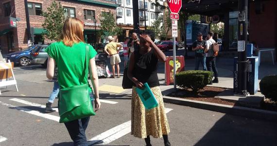 District 7 NACtivist Shaun Glaze petitions a farmers market shopper for her signature. Photo by Casey Jaywork