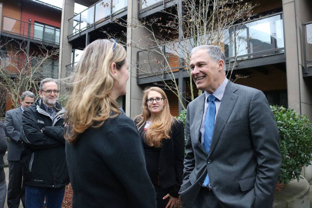 Photo by Nicole Jennings                                 Gov. Inslee greets new Issaquah Mayor Mary Lou Pauly outside the zHome housing development, the first zero-net-energy townhouse development in the United States.