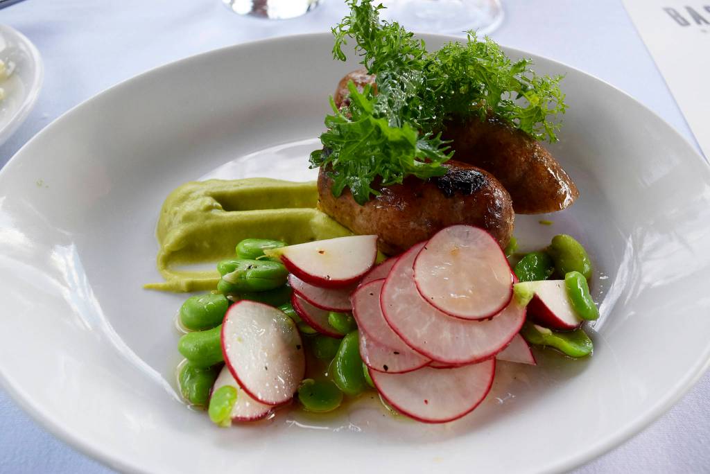 Grilled lamb sausage with fava bean, frilly greens, and 
marinated radishes from a Bastille Rooftop Garden Dinner. 
Photo courtesy Bastille Café & Bar