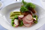 Grilled lamb sausage with fava bean, frilly greens, and 
marinated radishes from a Bastille Rooftop Garden Dinner. 
Photo courtesy Bastille Café & Bar