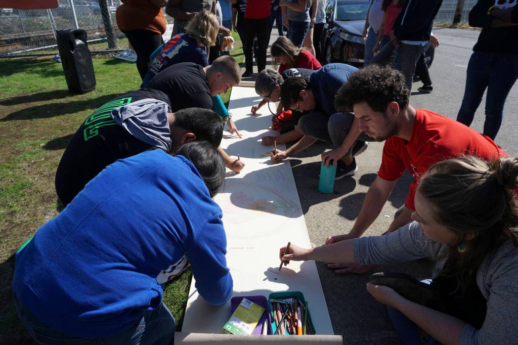 NWDC Resistance organizers write messages for the NWDC detainees outside of the facility on Sept. 1. Photo by Melissa Hellmann
