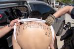 Task force members reveal a gang members tattoo during a July bust at an unspecified location. COURTESY PHOTO, U.S. Marshals Service