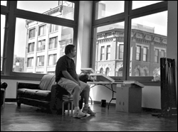 Photographer Dirk Park contemplates the view from his rent-controlled loft in the new Tashiro/Kaplan project.