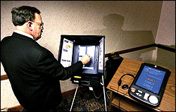 Snohomish County Auditor Bob Terwilliger demonstrates a Sequoia touch-screen voting machine last summer.