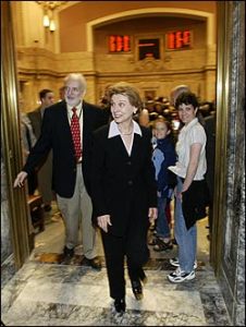 At session's end on Sunday, April 24, the governor smiles on behalf of fellow Democrats.