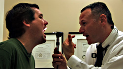 His doctor (right) looks in vain for some Super jokes in Benson's throat.