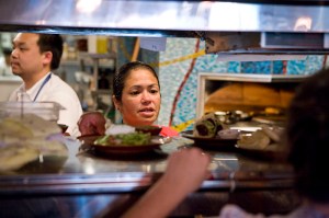 Owner and chef Maria Hines running the expo window at her restaurant, Golden Beetle.