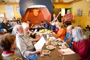 Greenwood Senior Center volunteers sing along with cafe attendees.