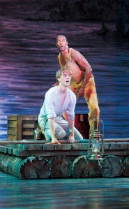 Photos By Jay Koh / Village TheatreJim, played by Rodney Hicks, and the ensemble perform a scene from ‘Big River,’ the Village Theatre Mainstage musical production based on Mark Twain’s ‘Adventures of Huckleberry Finn.’Huck, played by Randy Scholz (left), and Jim, played by Rodney Hicks, float down the Mississippi River on their raft in a scene from the Village Theatre Mainstage musical production of ‘Big River.’