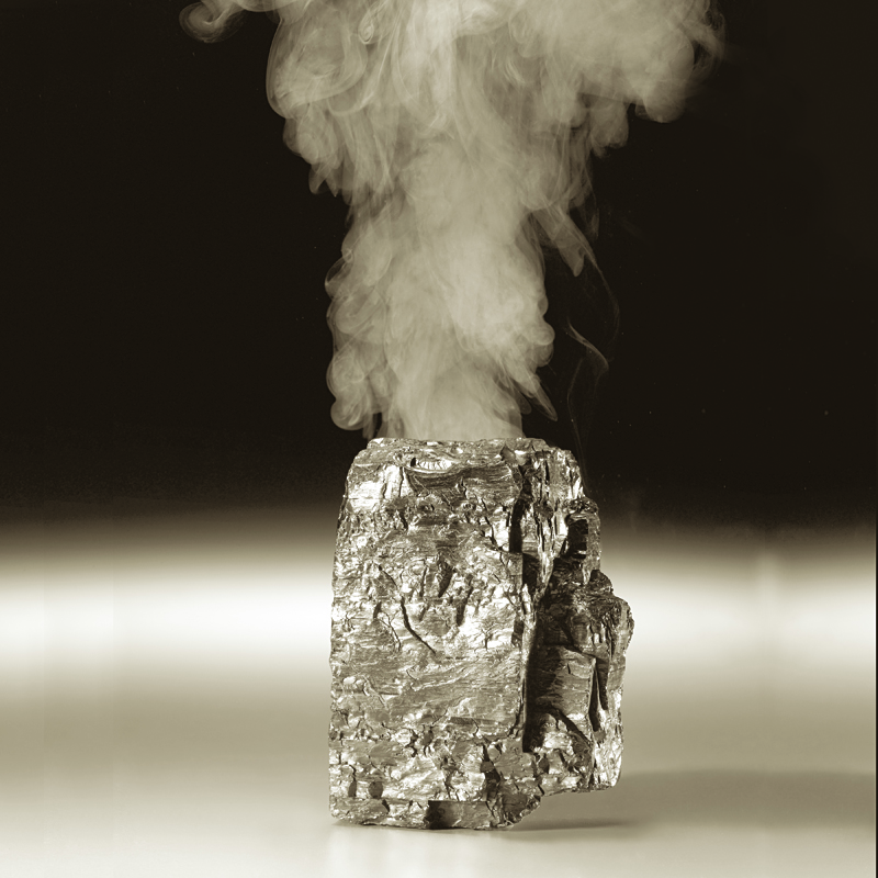 Piece of coal with smoke coming out of top