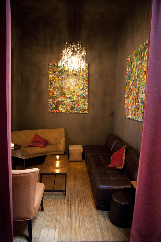 A similarly patterned interior wall separates the dining area from the bar and a loungy area partially concealed by long red drapes.