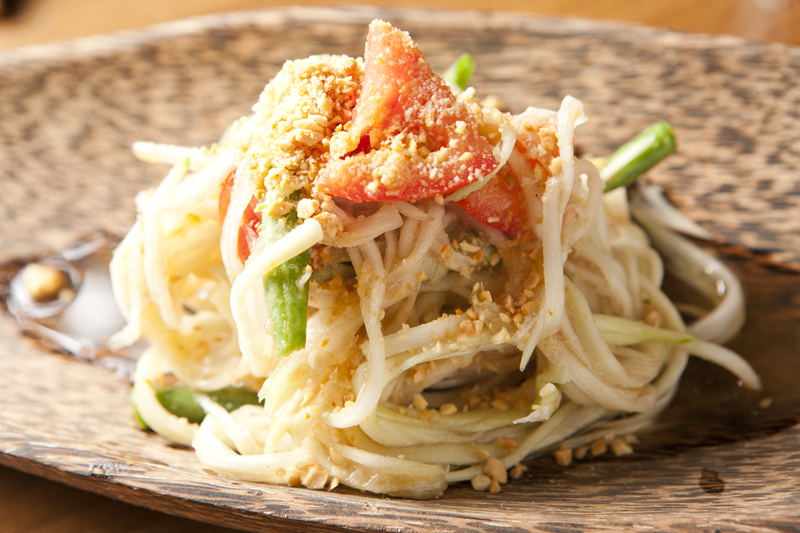 Som thum—fresh spicy salad of green papaya, cherry tomato, green bean, thaichili, roasted peanuts tossed in tangy lime & palm sugar dressing.