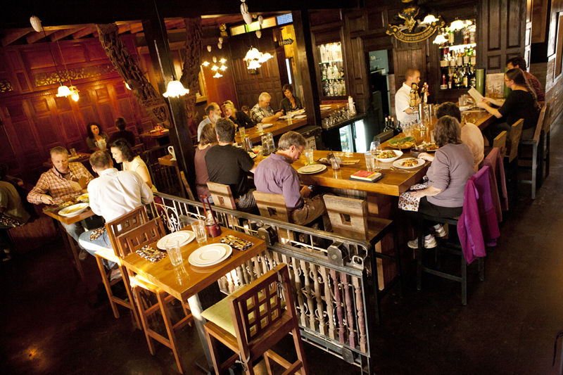 The most interesting scenes unfold at the restaurant's front door. It is here where Vashon Islanders, who've anxiously waited a year for May to open, get their first glimpse of the lemongrass-scented refuge that Chaleoy has created. They inevitably swing their gaze around the 60-seat room, cloaked in rich teak and mahogany panels that make the space feel as special and secure as a ship captain's quarters, perhaps alighting first on the central u-shaped bar that serves all manner of alcohol.