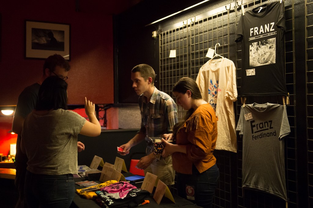 Two members of the Carnivores selling merch after their set.