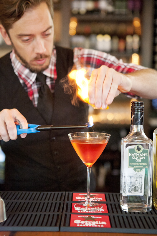 Putting the final touches on the cocktail. The orange peels are flammable, explains bartender, Greg West.