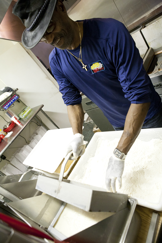 Dipping the chicken into the batter and back into the flour.