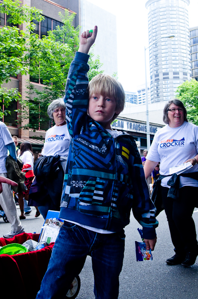 A young marcher tosses out small rings to the crowd.