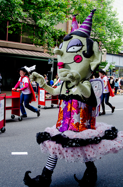 A large-costumed participant marching with the King County Library System.