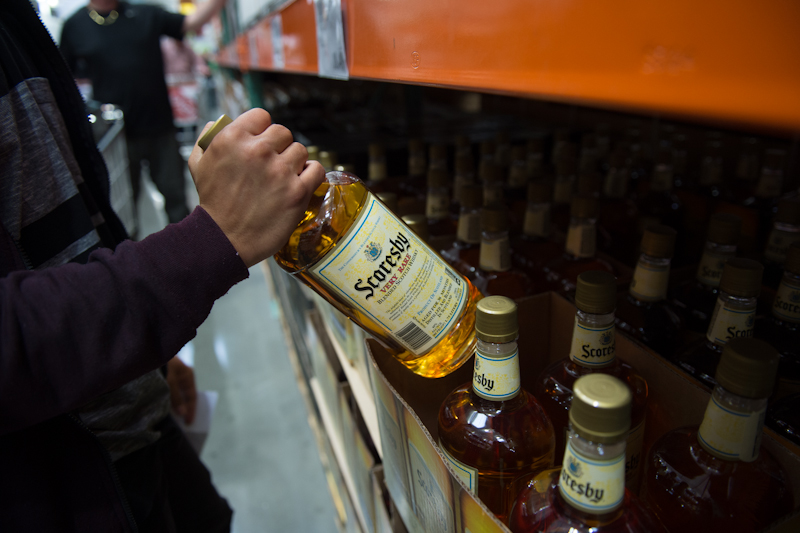 A customer picking up a bottle of Scotch.