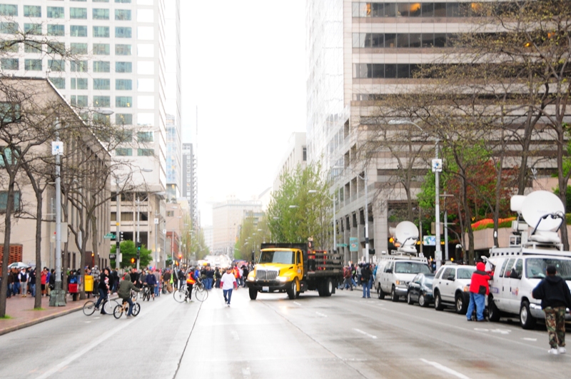 As the crowd arrives to rally on Second Avenue between Wells Fargo and the Federal Building, a yellow truck pulls out.
