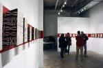 These ceramic installations line the wall on a single red strip spanning from corner to corner.