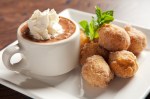 Tiny cinnamon-dusted doughnuts accompanied by a mug of chocolate sorbet capped with Bailey's whipped cream.