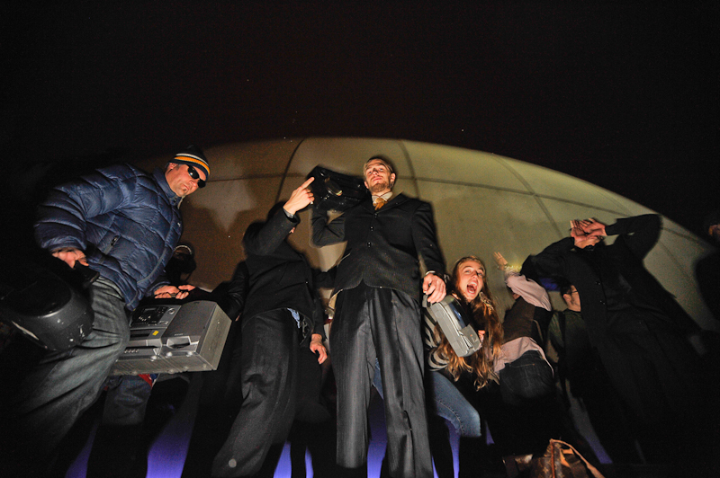 Clad in business attire and wielding boomboxes, hundreds of revelers romped around