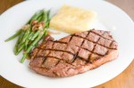 Steak served with green beans and a square of potato gratin.