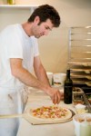 Owner Jerry Corso building the Ortolana Pizza.  He uses braising greens, coppa, smoked mozzarella and sun gold tomatoes.
