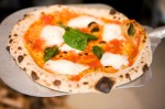 A Margherita pizza with tomato, basil and extra virgin olive oil with mozzarella di buffalo.