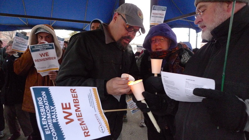 During a protest on February 26 in downtown Ellensburg, Mark Holloway helps light a candle.