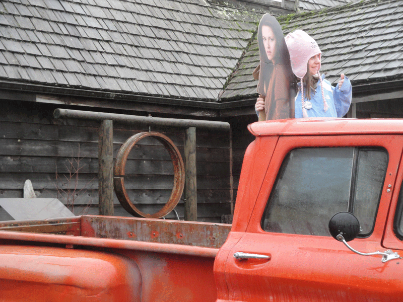 A young Twilight fan poses with a cardboard cutout of Bella (Kristen Stewart) in the car Bella drove in the films.