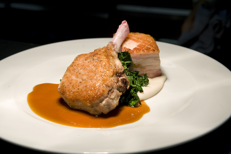 Duo of pork aE“ roasted chop, crispy belly, lacinato kale, white bean puree, maple bourbon jus.