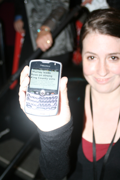 An attendee keeps up on the election results with her phone.