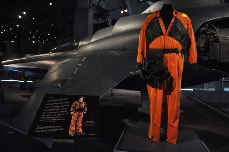 A deckhand costume in front of a life-sized Viper Mark VII spacecraft, one of three life-sized spacecraft from the series on display at the exhibit