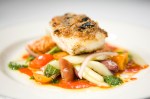 Olive-Crusted Alaskan Halibut with panzanella salad, basil pesto, and broken tomato vinaigrette.