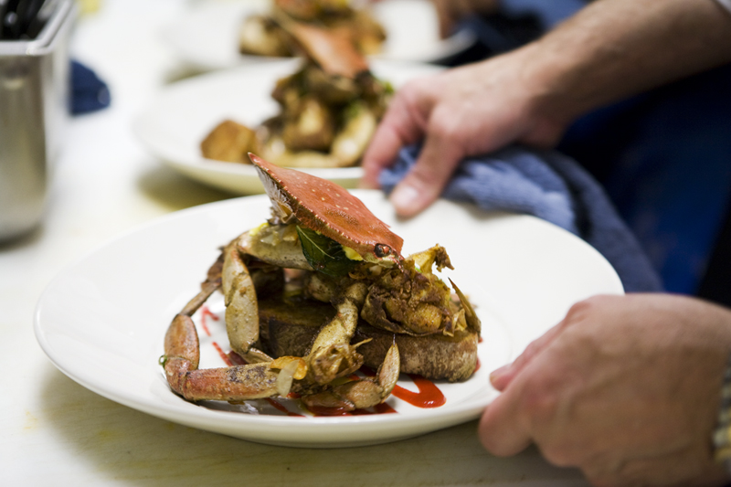 Whole Angry Dungeness Crab with toasted garlic, basil, orange zest, and Serrano chilies.