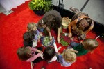 Children gather around to learn how to make bookmarks out of plants with the Wilderness Awareness School during the Green Festival in Seattle, Wash., on Sunday, June 6, 2010.  (Photo by Matthew Williams for The Seattle Weekly)
