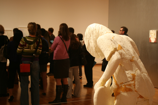 Press entourage overlooked by a sculpture of Cobain.