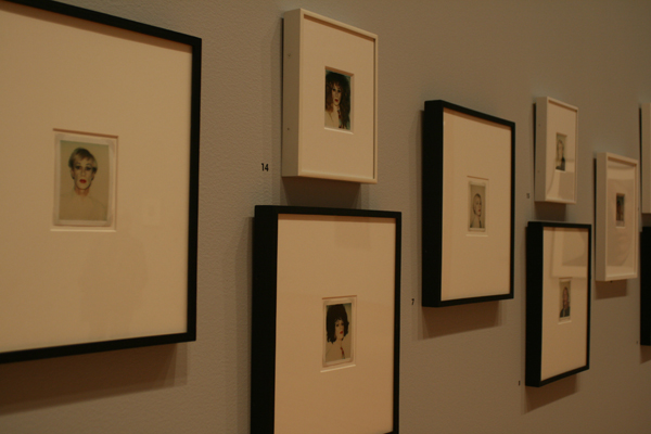 A collection of self-portraits of Warhol in various states of drag/un-drag.