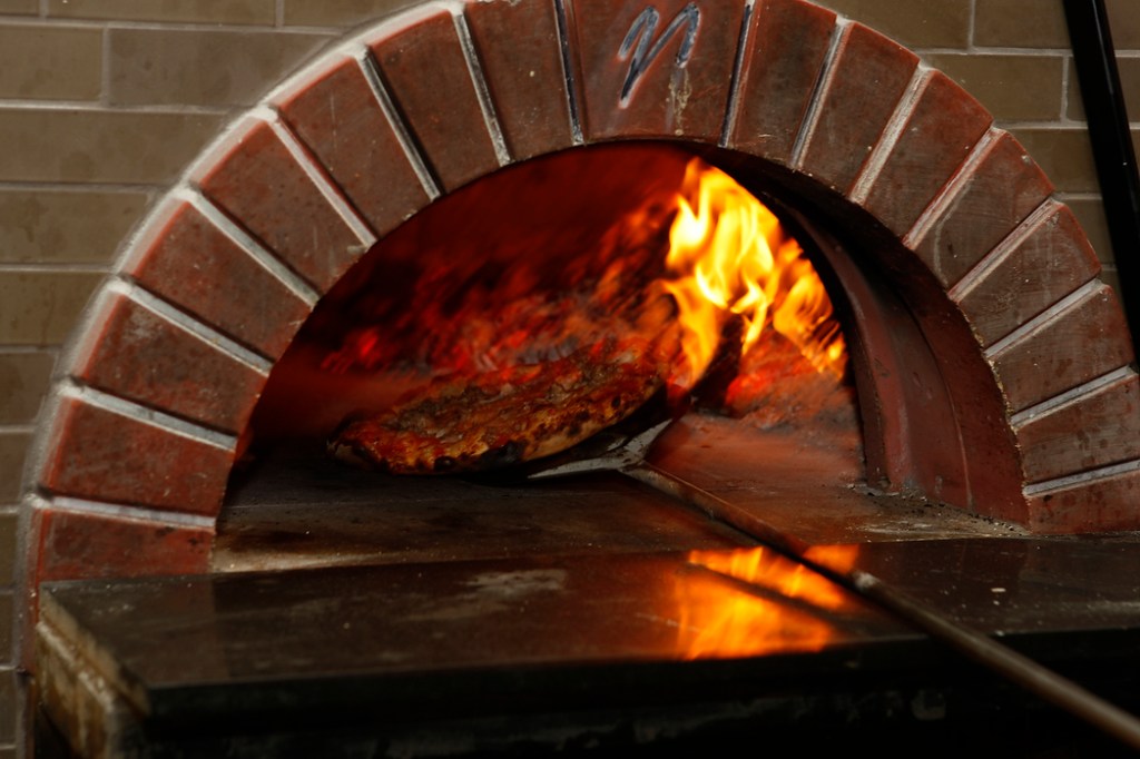 SEATTLE, WA FRIDAY OCT. 4, 2009 Delancey Pizza in Ballard Brandon Pettit unloads a pie from the wood burning oven at Delancey Pizza in Ballard. Pettit owns the restaurant with wife Molly Wizenberg. Photos by Kevin Casey/Seattle Weekly