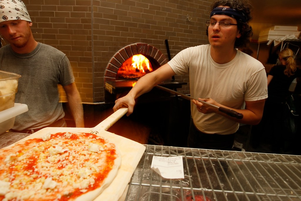 SEATTLE, WA FRIDAY OCT. 4, 2009 Delancey Pizza in Ballard Brandon Pettit unloads a pie from the wood burning oven at Delancey Pizza in Ballard. Pettit owns the restaurant with wife Molly Wizenberg. Photos by Kevin Casey/Seattle Weekly