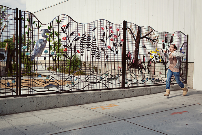 Isobel runs past the glass art wall in front of the Boys & Girls Club.