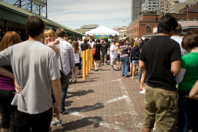 Two birds with one stone: waiting in line for cheese and building a base tan for summer.