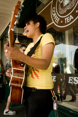 Whitney Monge serenades cheese goers outside the famous first Starbucks.