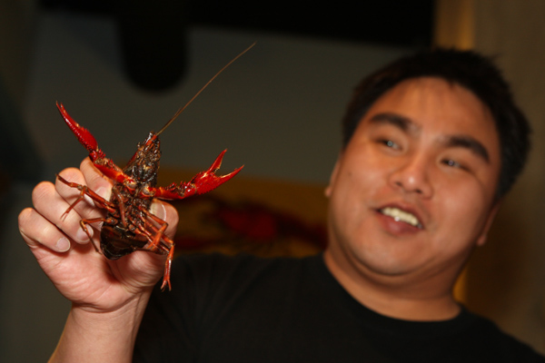 Trieu Dinh at Crawfish King with a live crawfish in Seattle on Sunday May 3, 2009. (Kevin P. Casey/Seattle Weekly)